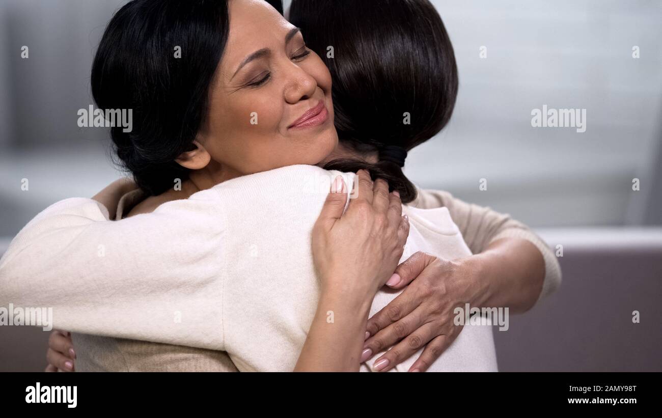 Mother embracing young daughter, empathy and tenderness, love and maternity Stock Photo