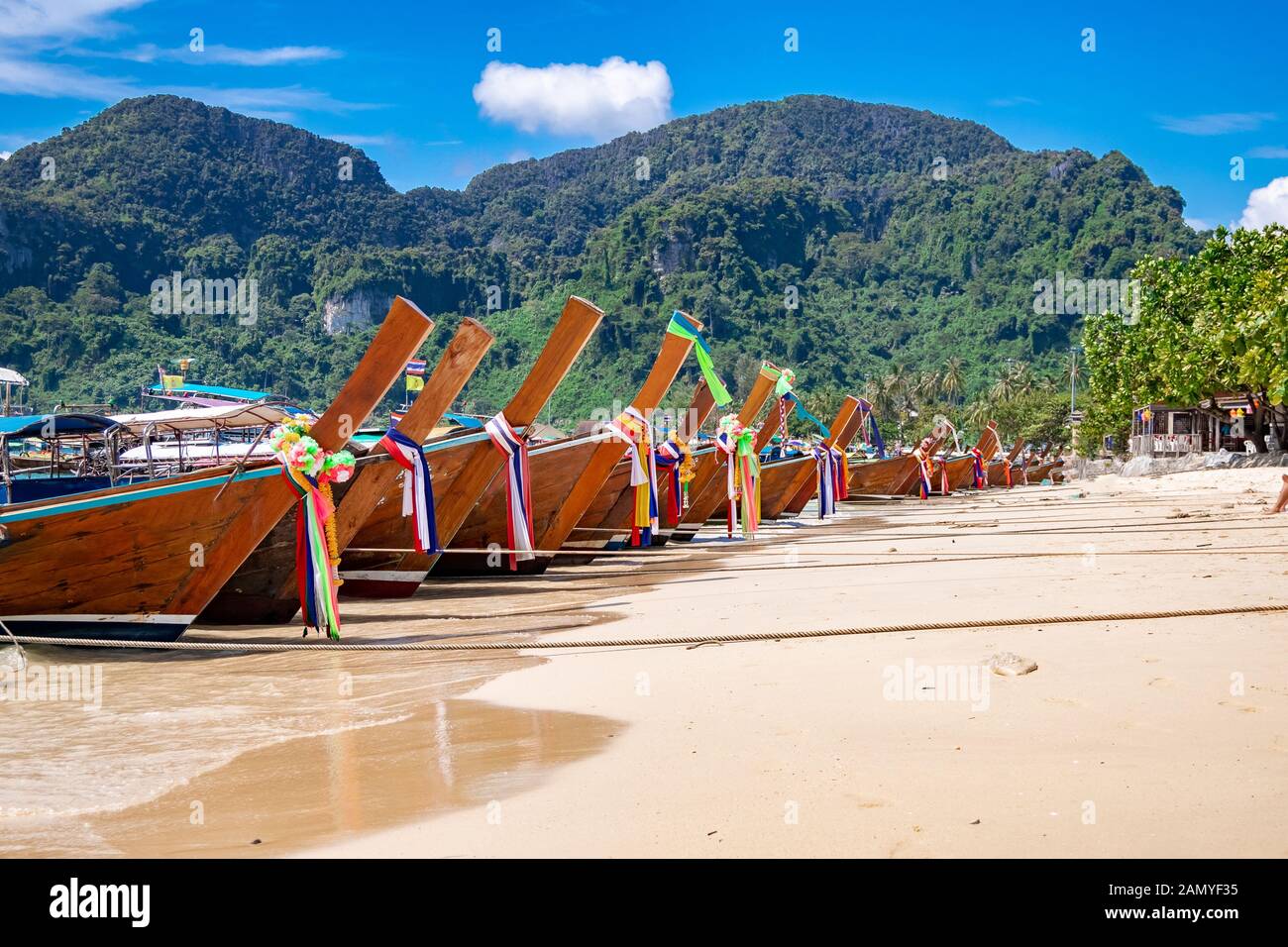 traditional wooden longtail boats parked at a beach in Phi Phi Island. Clear water and clean beach. Stock Photo