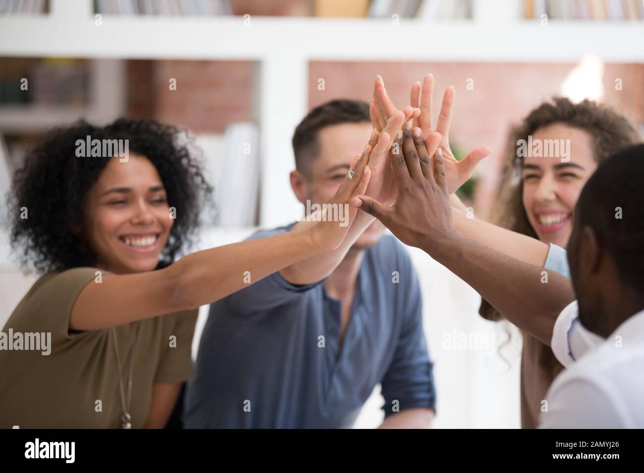 Motivated diverse people give high five for shared success Stock Photo ...