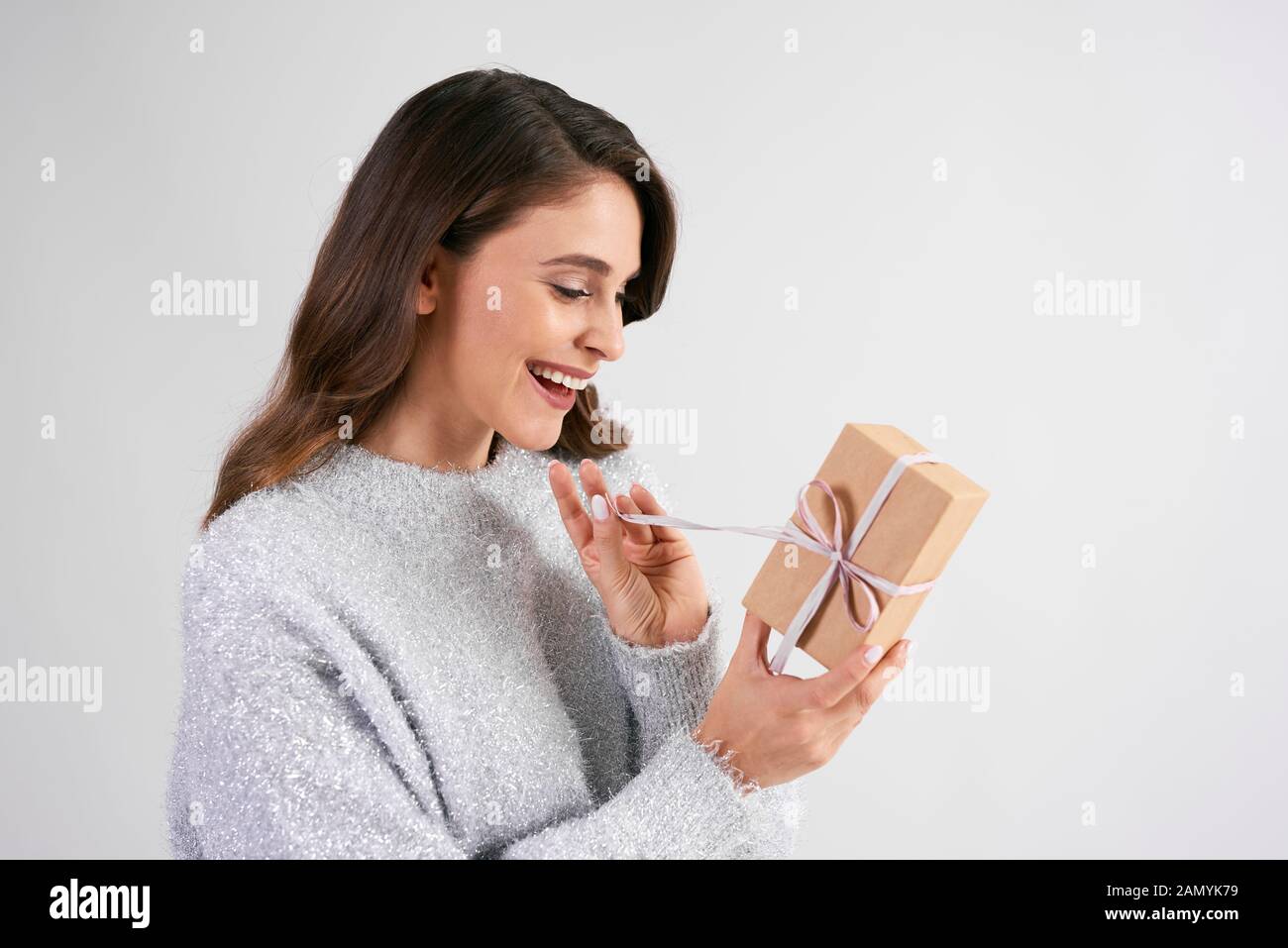 Happy woman opening the gift in studio shot Stock Photo
