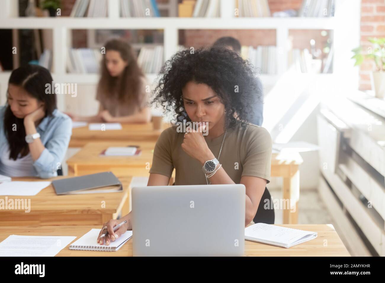 Pensive worker use laptop working in shared office Stock Photo