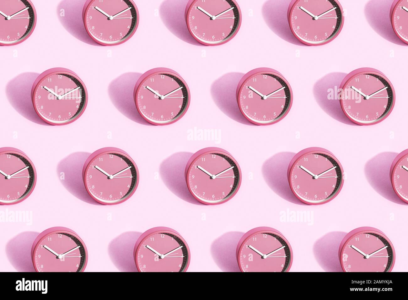 Many pink alarm clock on pink background. Time management concept. Stock Photo