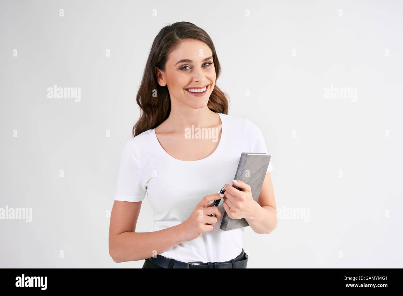 Smiling woman holding a book in studio shot Stock Photo