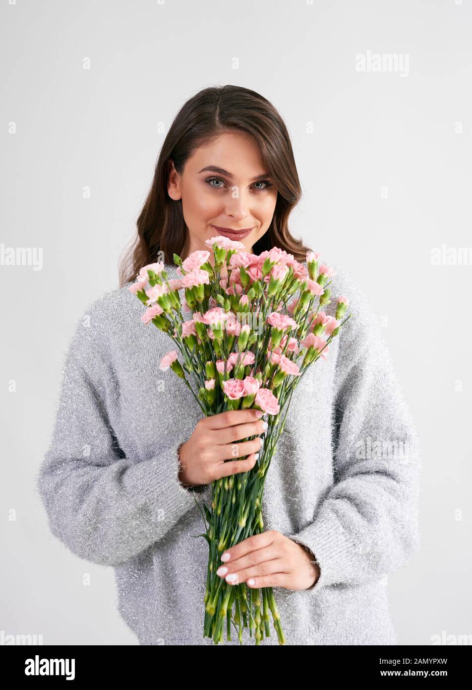 Beautiful woman holding bunch of flowers in studio shot Stock Photo - Alamy