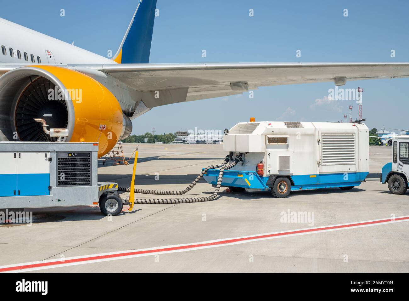 Big modern commercial plane parked on airport runway and connected to ground supply power unit. Aircraft maintenance service and check-up before Stock Photo