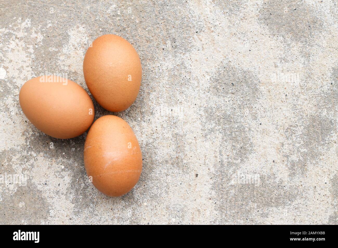 Top view three brown eggs on concrete. Stock Photo