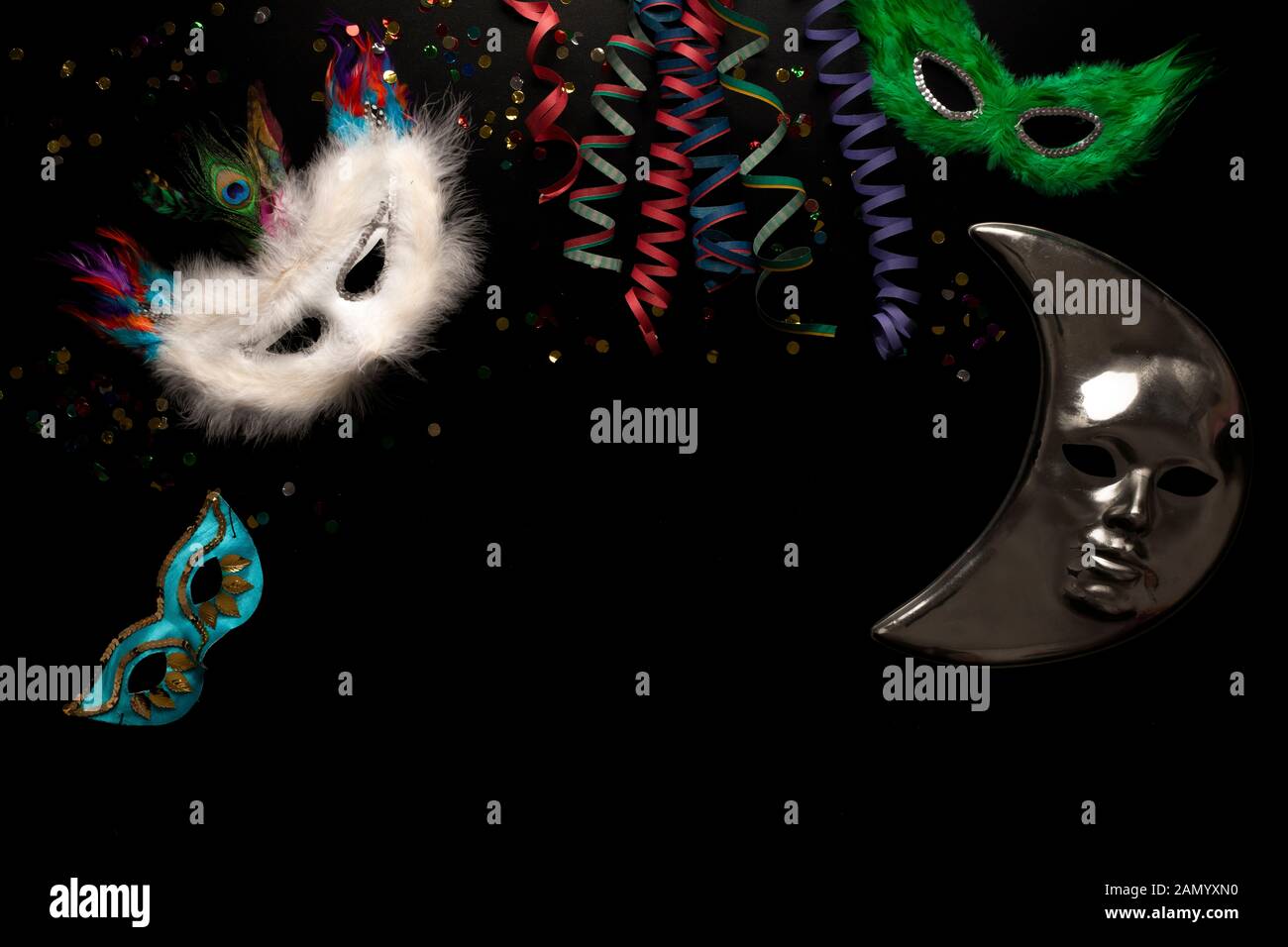 Carnival objects on a black background. Coiled streamers, masks ...