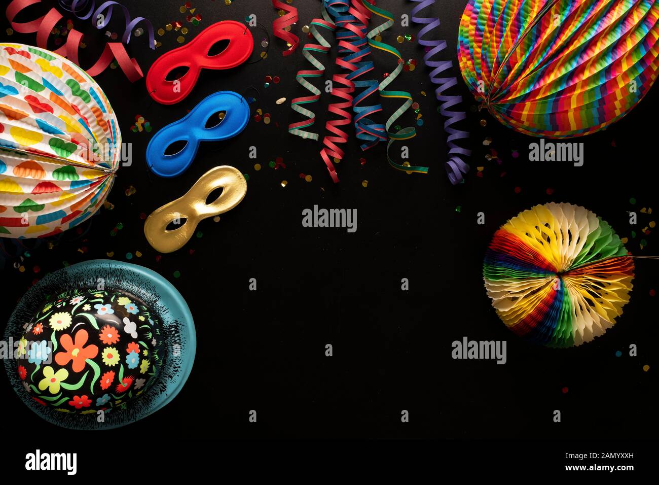 Carnival objects on a black background. Coiled streamers, masks, paper skeleton, confetti, paper balloons and many other carnival objects Stock Photo