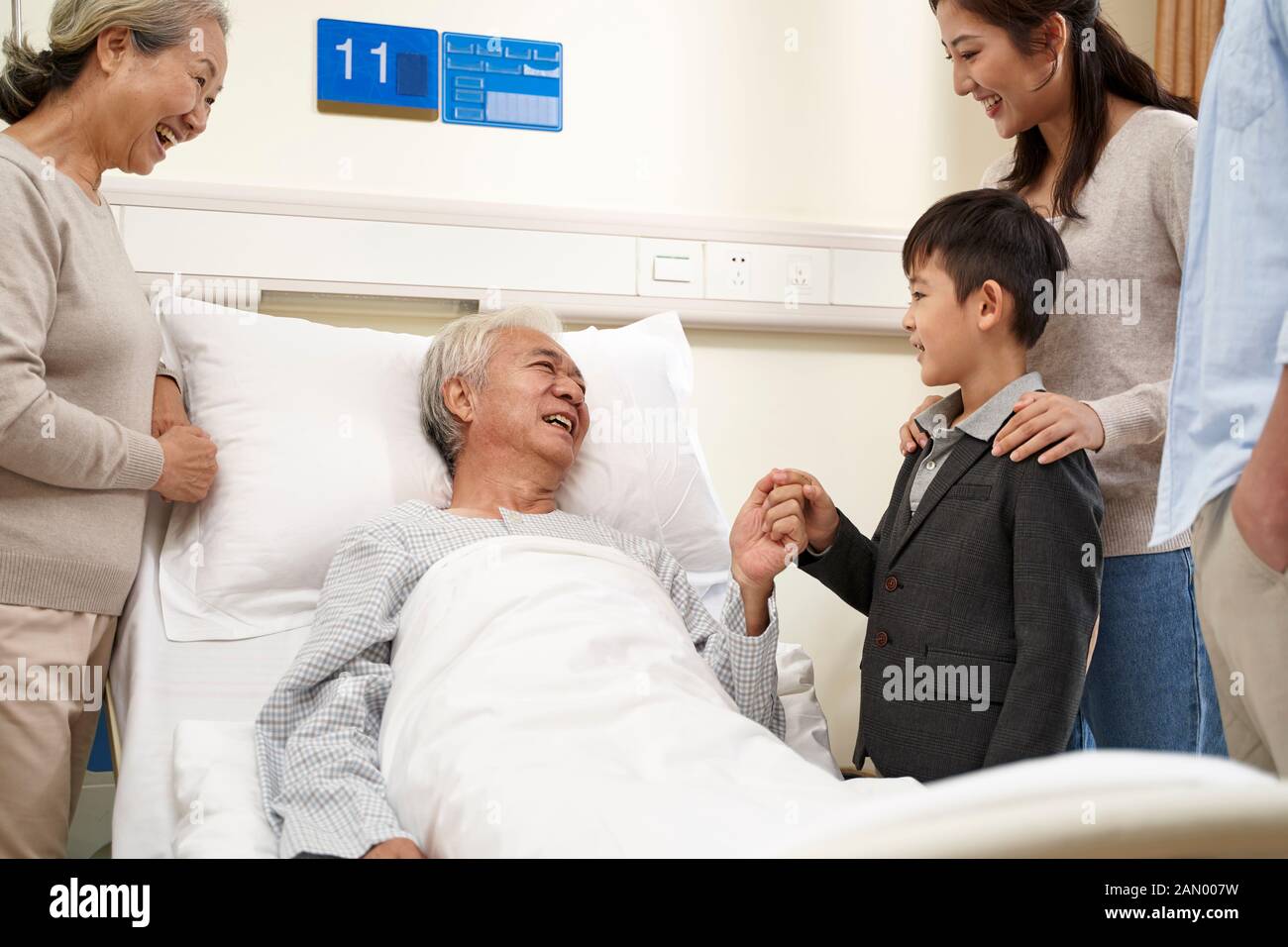 asian family with child visiting grandparents in hospital Stock Photo
