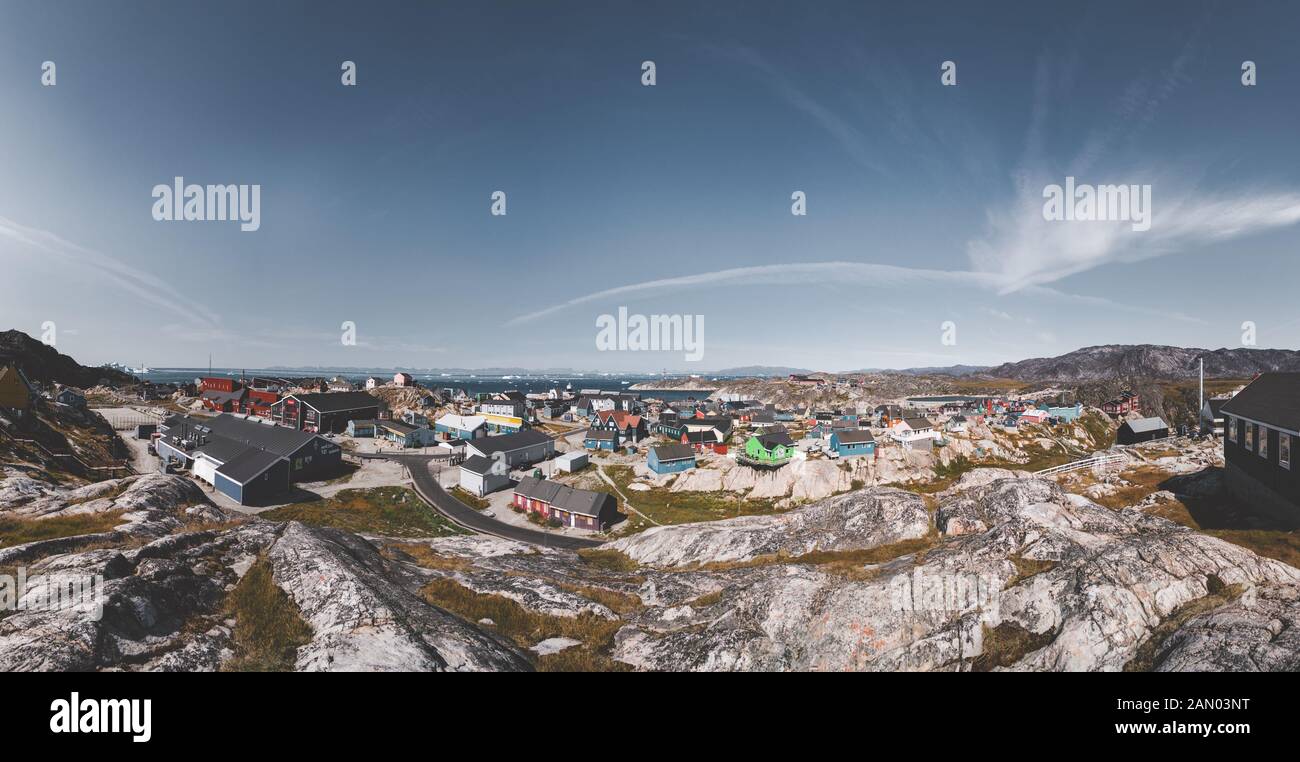 Aerial View of Arctic city of Ilulissat, Greenland. Colorful houses in the center of the town with icebergs in the background in summer on a sunny day Stock Photo