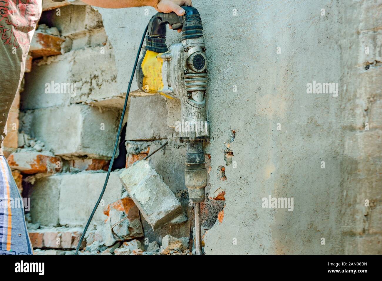 A man with a jackhammer makes an opening in the wall Stock Photo Alamy