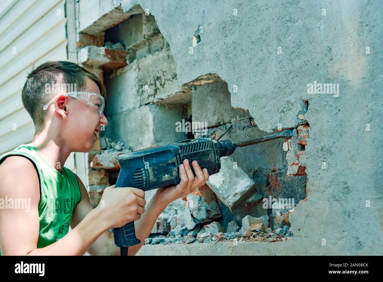 A man with a jackhammer makes an opening in the wall Stock Photo Alamy