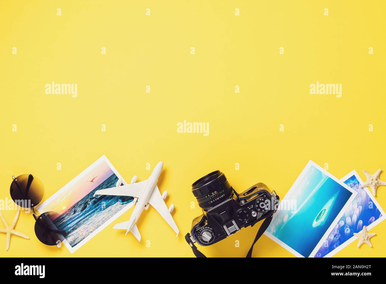 Toy airplane, glasses, photographs and a camera on a colored paper background with copy space. Travel concept Stock Photo