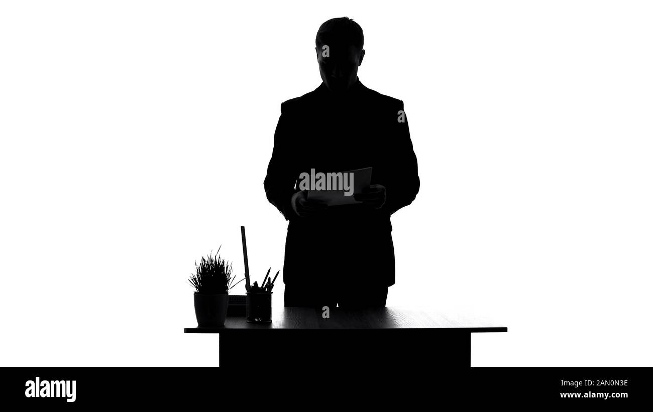 Office worker reading contract documents standing near table, analyzing report Stock Photo