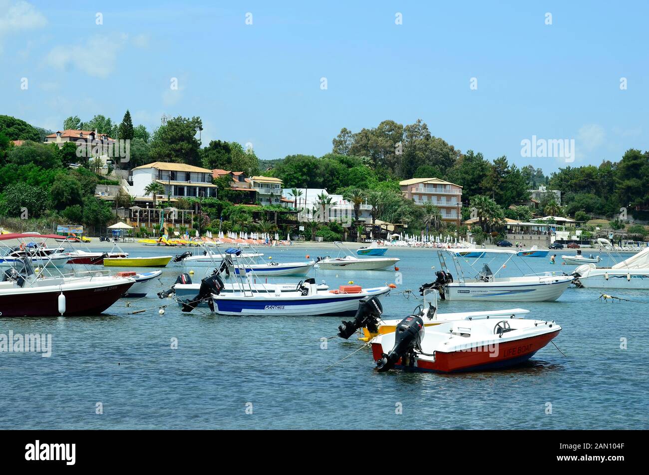 Zakynthos, Greece - May 24th 2016: Unidentified people on beach of Agia Sostis and boats on the island in Ionean sea Stock Photo