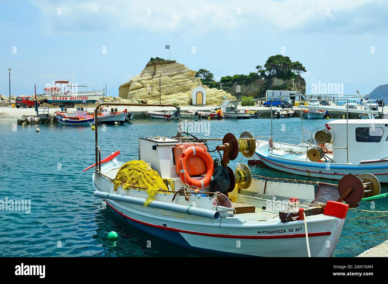 Zakynthos, Greece - May 24th 2016: tiny harbor with boats and chapel in Agia Sostis on the greek island in Ionian sea Stock Photo