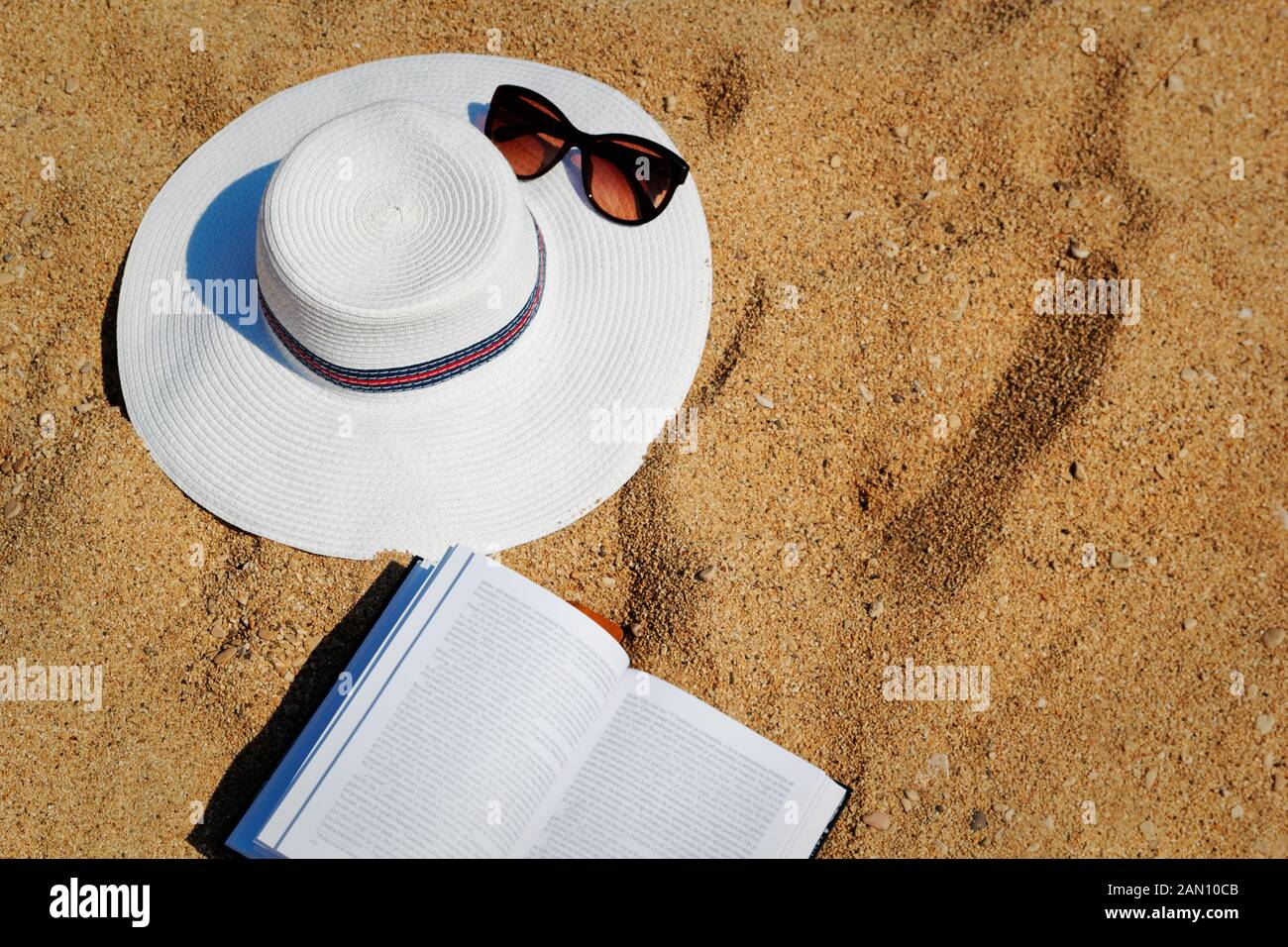 Summer beach bag with straw hat and sunglasses on sandy beach Stock Photo -  Alamy