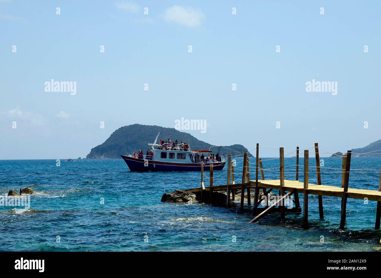 Zakynthos, Greece - May 24th 2016: Unidentified people on cruising boat and Marathonissi island aka Turtle island in background Stock Photo