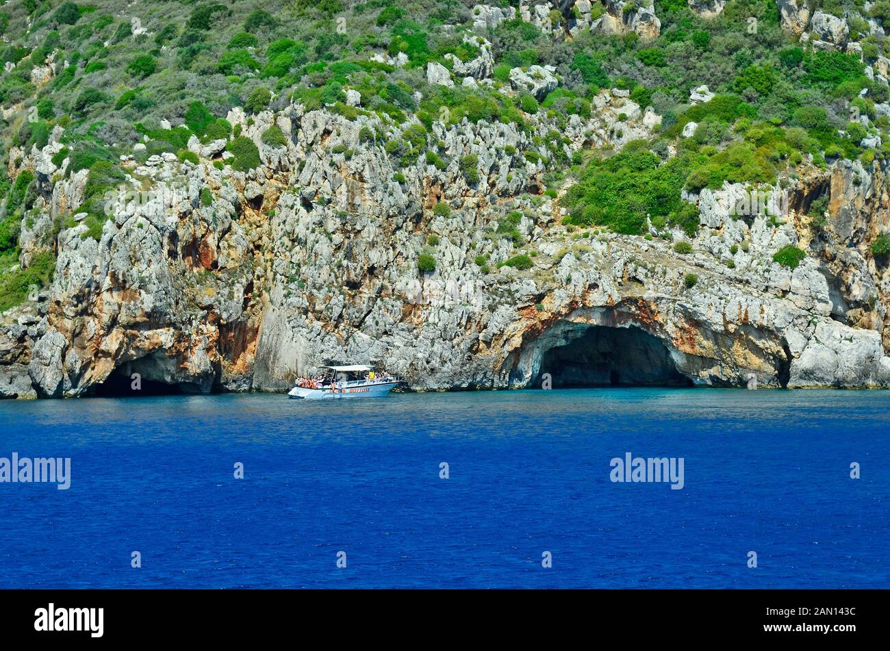 Zakynthos, Greece - May 25th 2016: Unidentified people, excursion boat and natural cave on eastern coast of the island in Ionean sea Stock Photo
