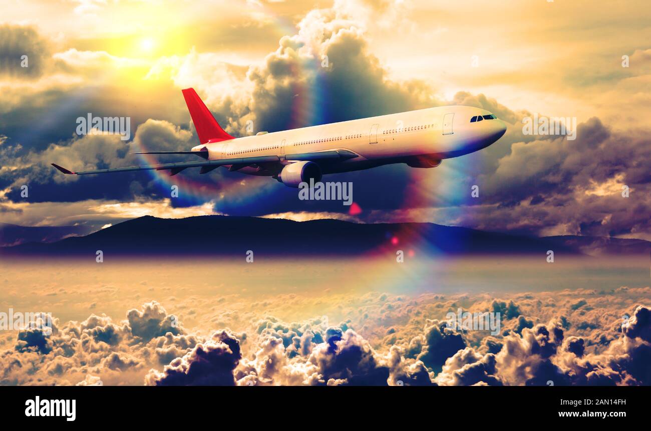 Commercial airplane flying over the sunset landscape. Stock Photo