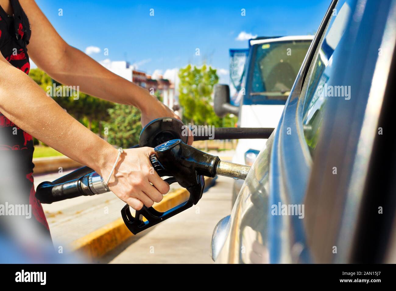 Woman pouring gasoline into the car at the service station.fuel station and car concept Stock Photo