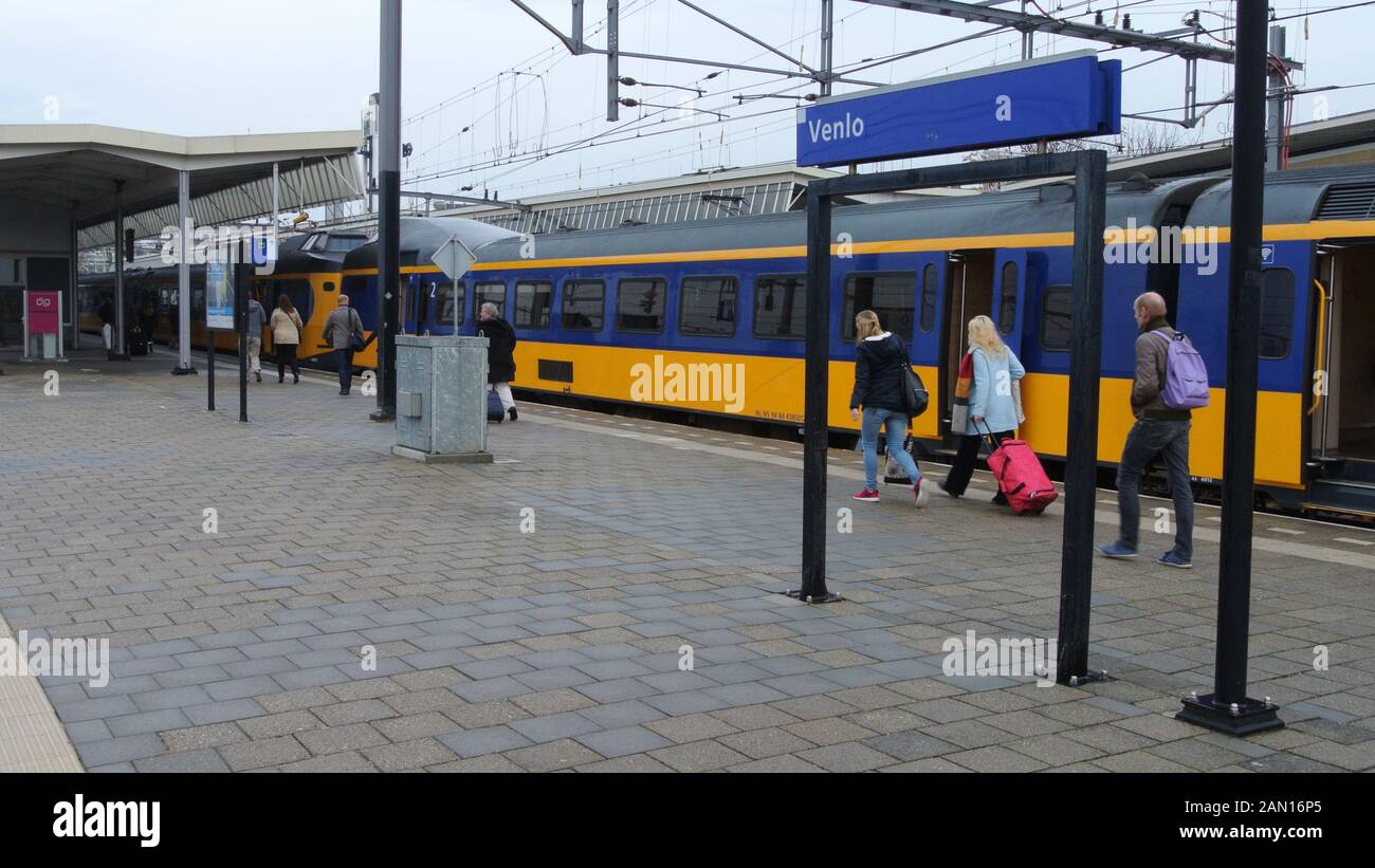 Passengers walking along a platform at Venlo railway station, in the Netherlands. Stock Photo