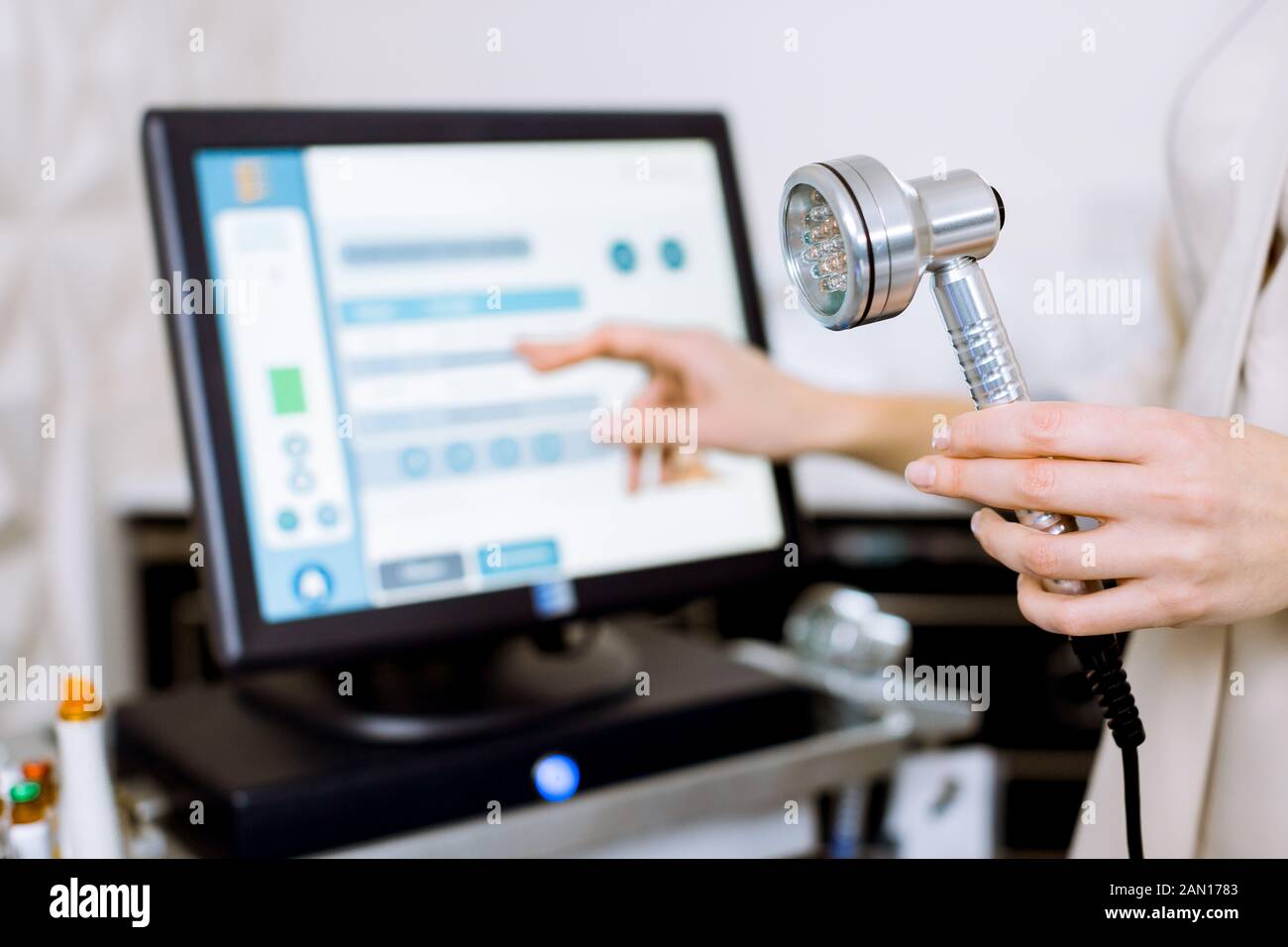 Facial Beauty Treatment. Cropped image of hand of professional woman cosmeolotgist holding a tool for Led Light Therapy, Anti-aging treatments and Stock Photo