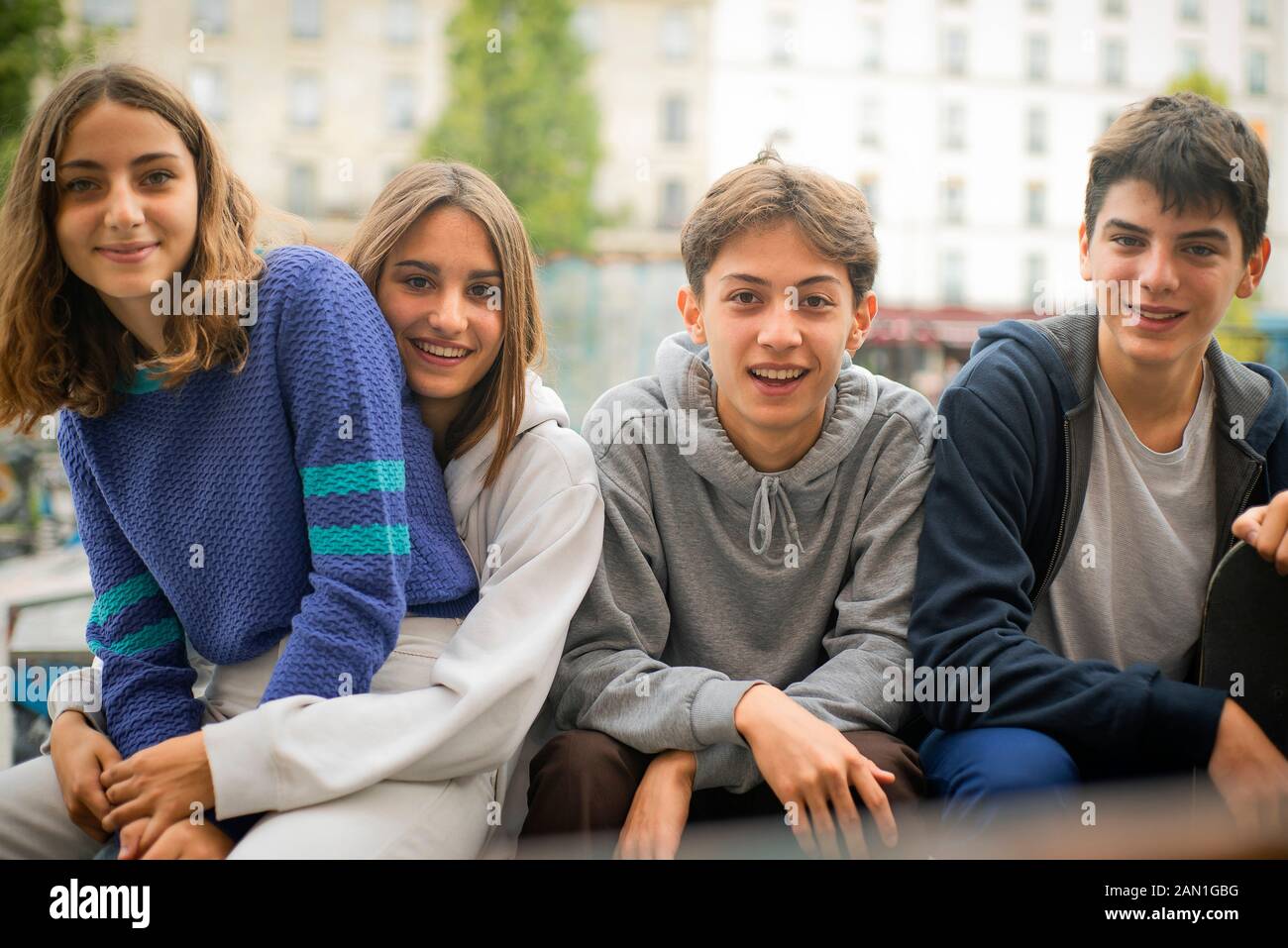 Teenage friends sitting outdoors Stock Photo
