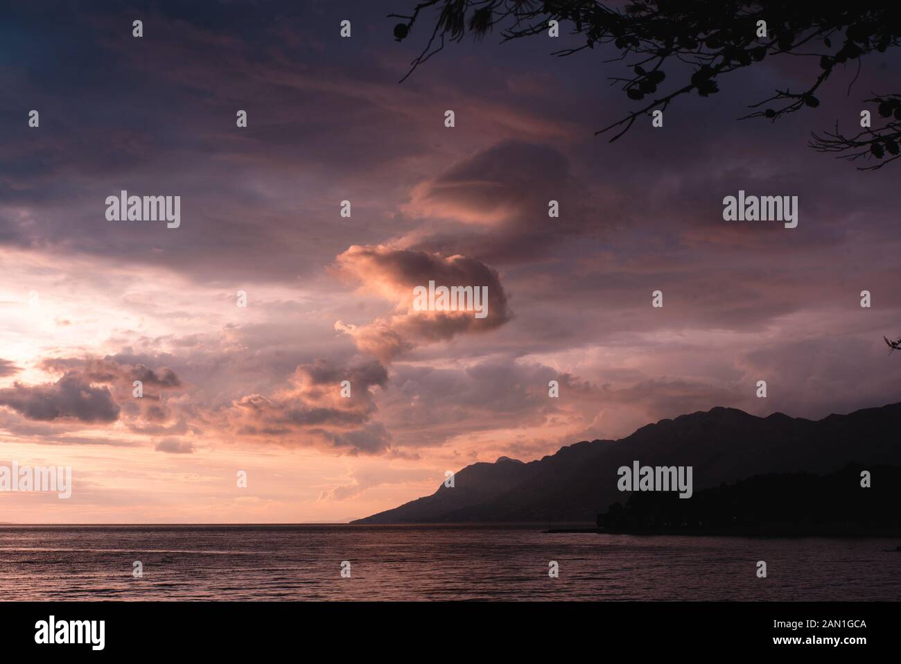 View of sea and mountain against cloudy sky Stock Photo