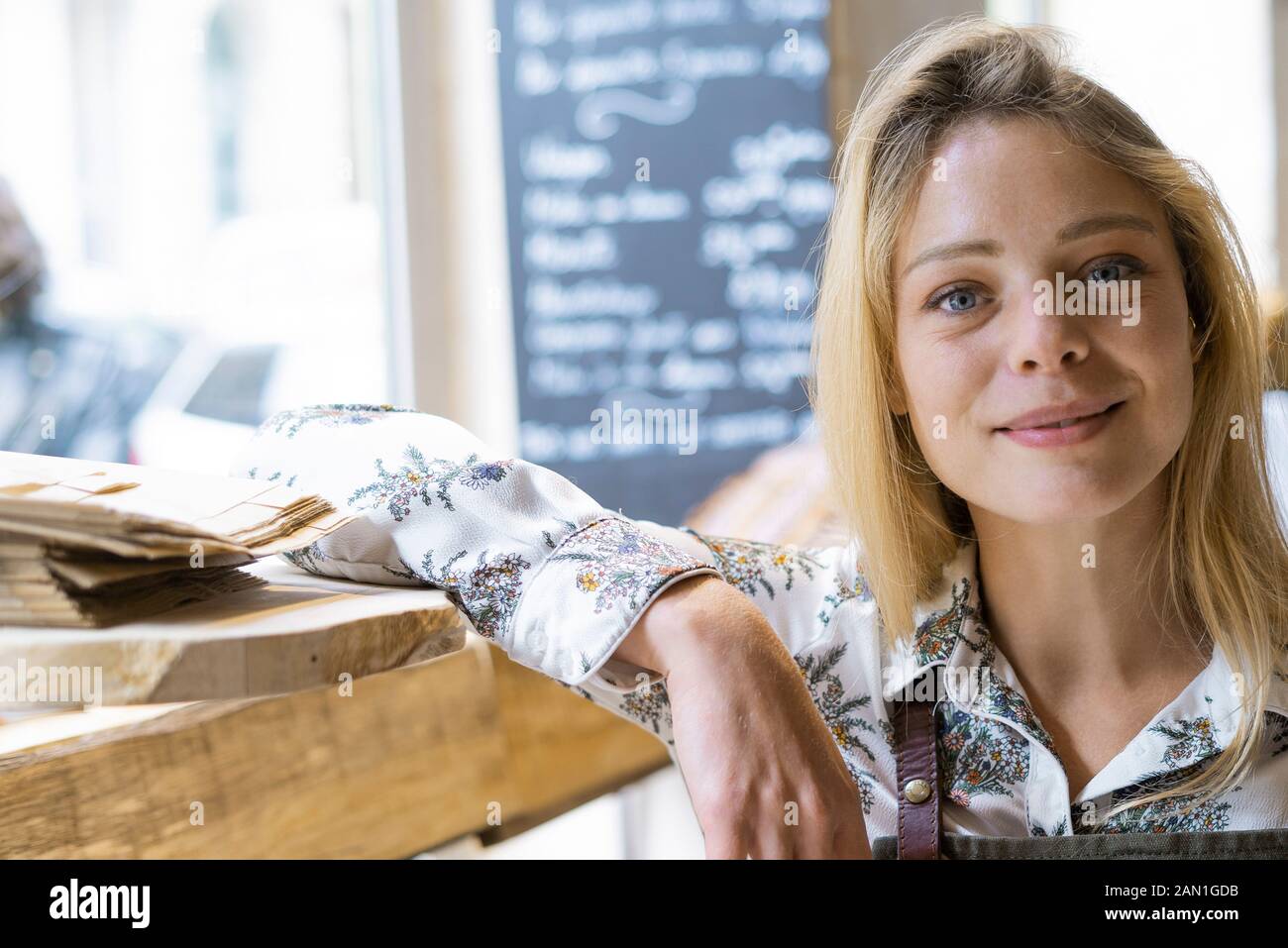 Smiling young woman standing in grocery store Stock Photo