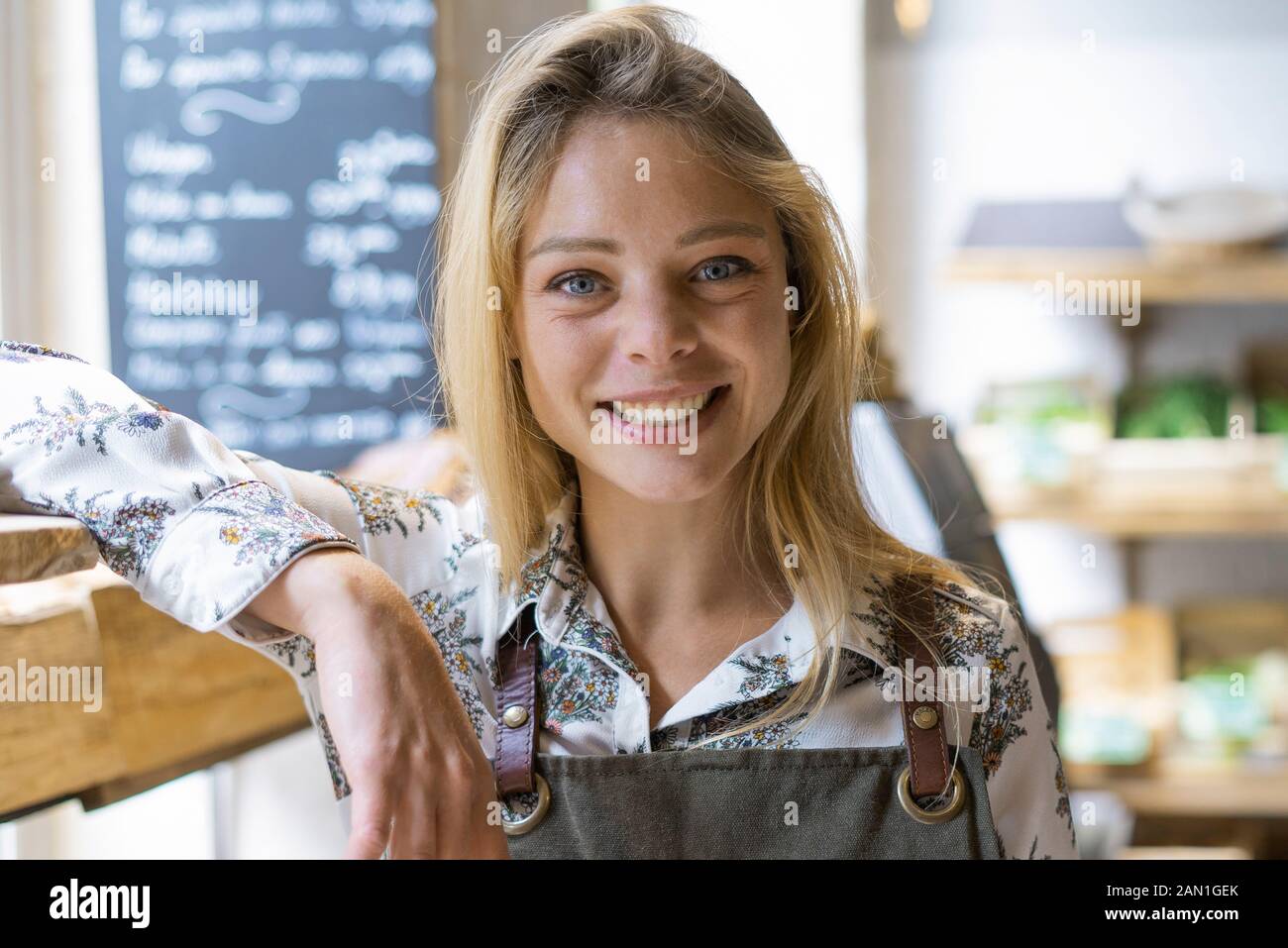Smiling young woman standing in grocery store Stock Photo - Alamy