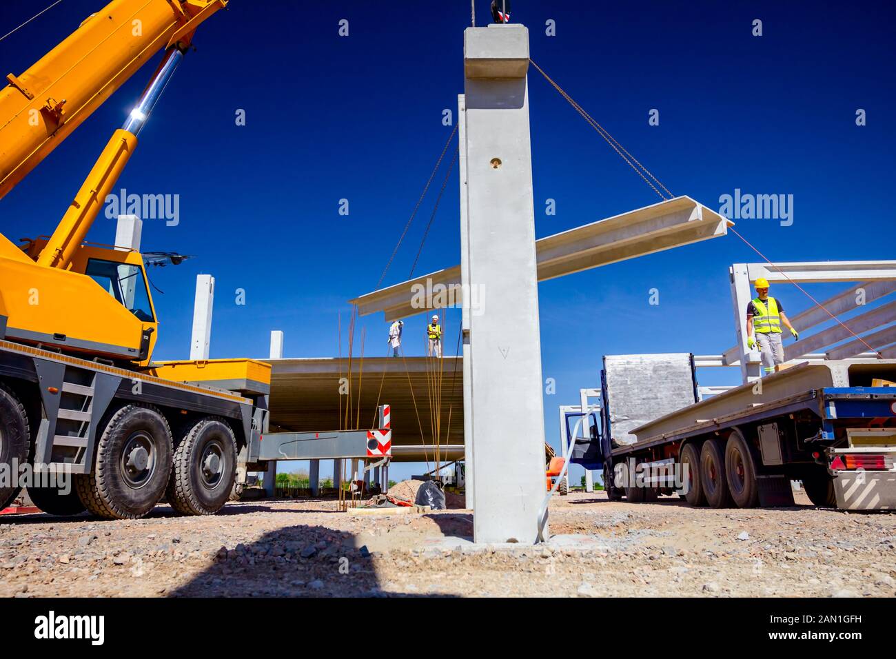 Unloading Hook Worker is preparing crane hook for unloading concrete joist from truck ...