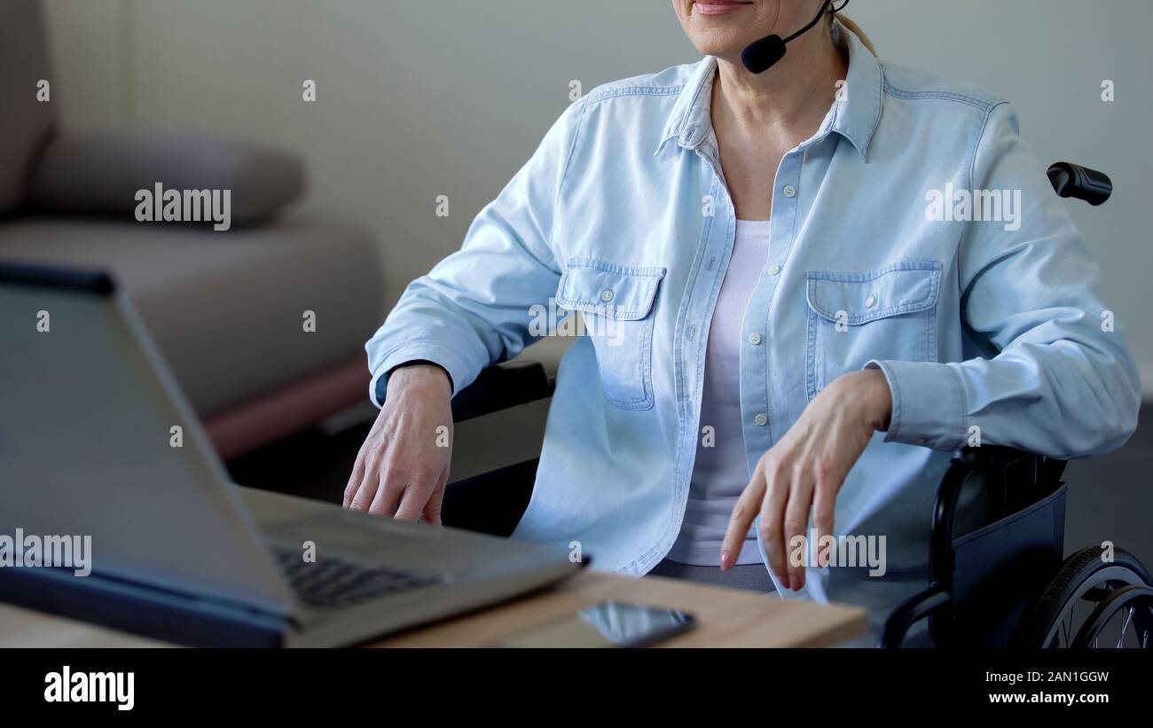 Disabled female consultant with headset talking with client, working on