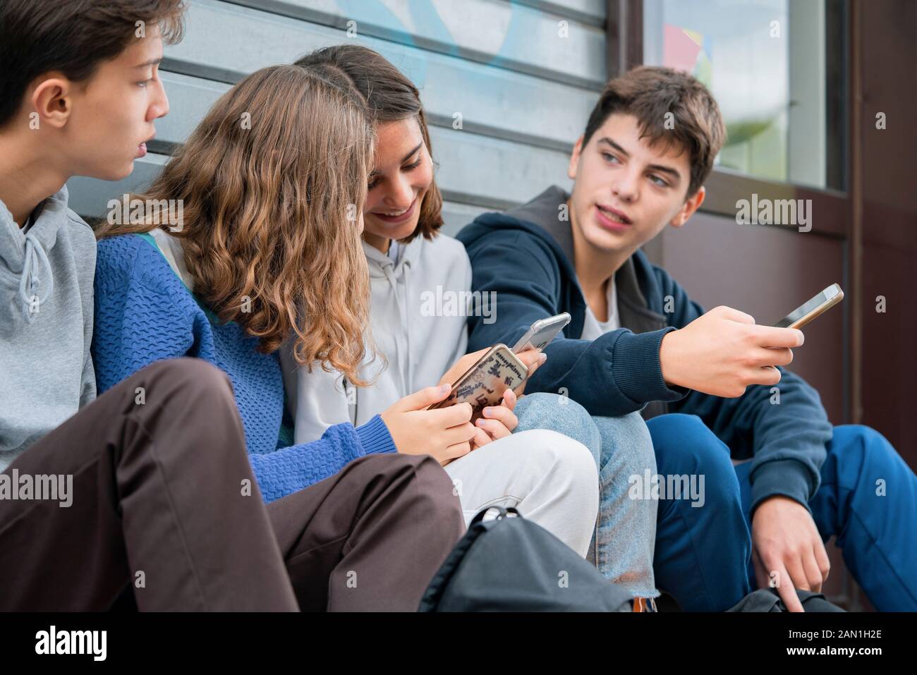 Friends using smartphone outdoors Stock Photo