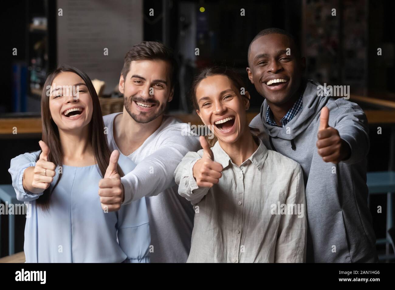 Portrait of happy young people show thumbs up recommending service Stock Photo