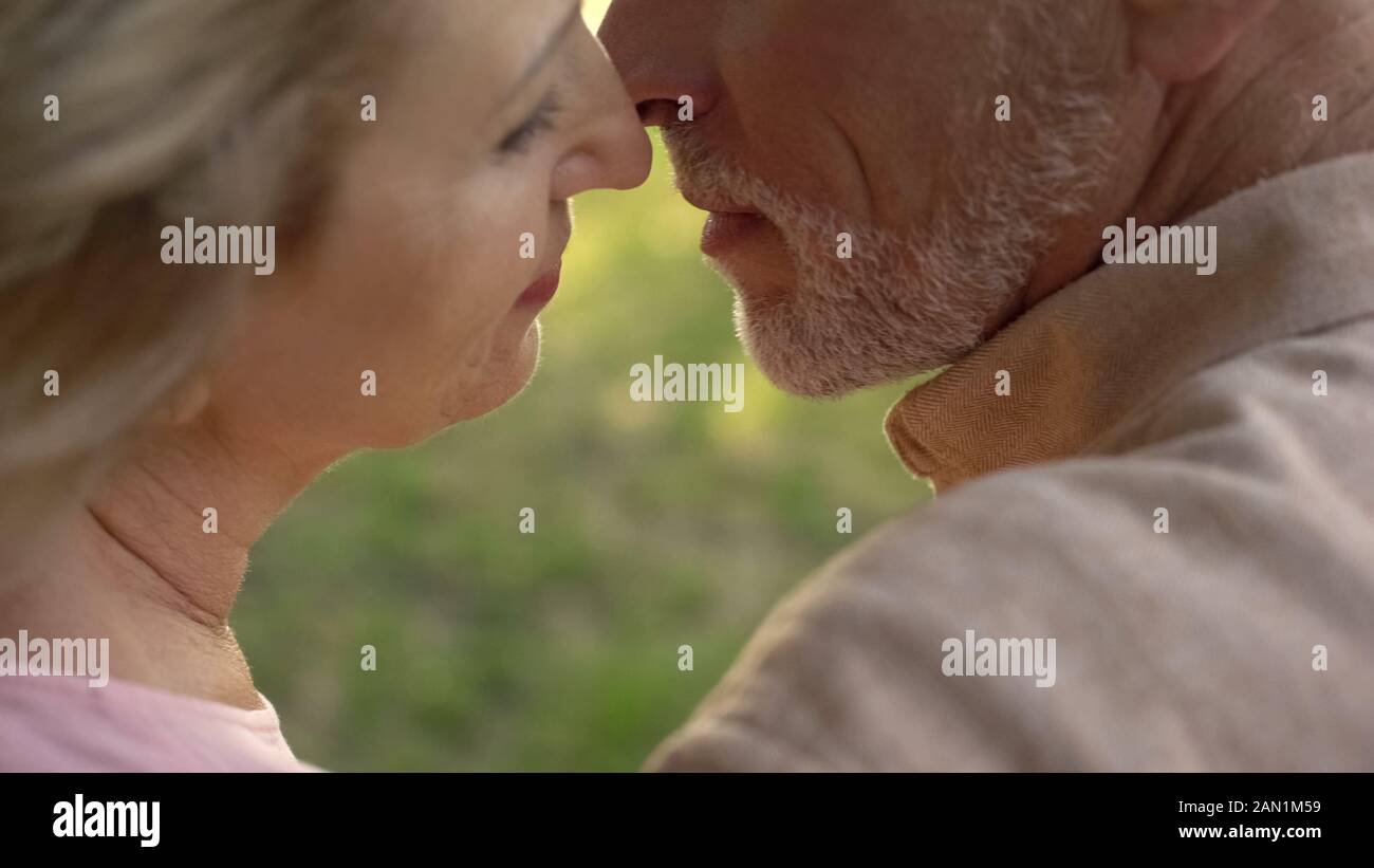 Aged husband and wife kissing closeup, love feeling, married couple togetherness Stock Photo