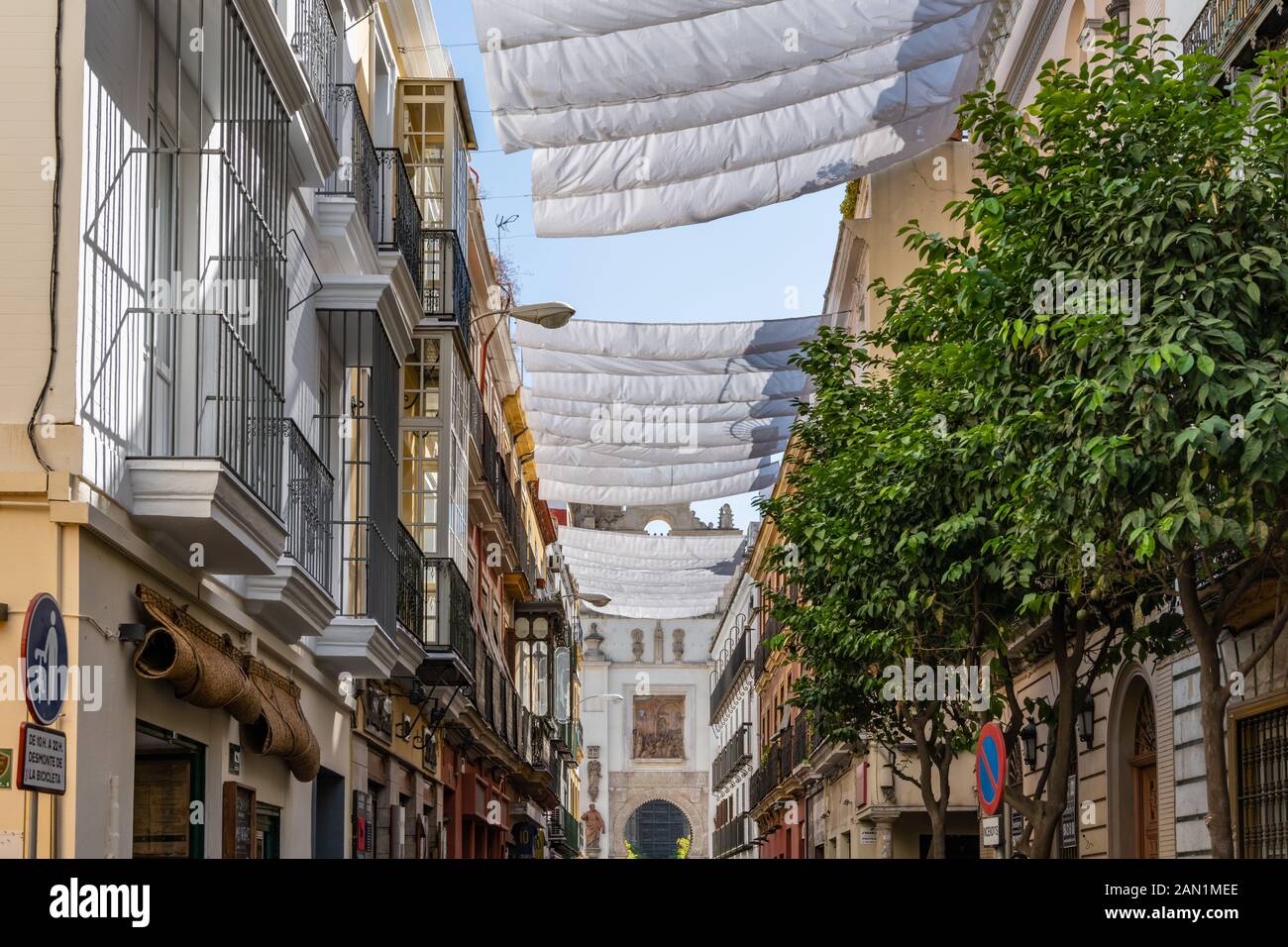 White sunshades cover the Calle Hernando Colón with its colourful shops and cafes Stock Photo
