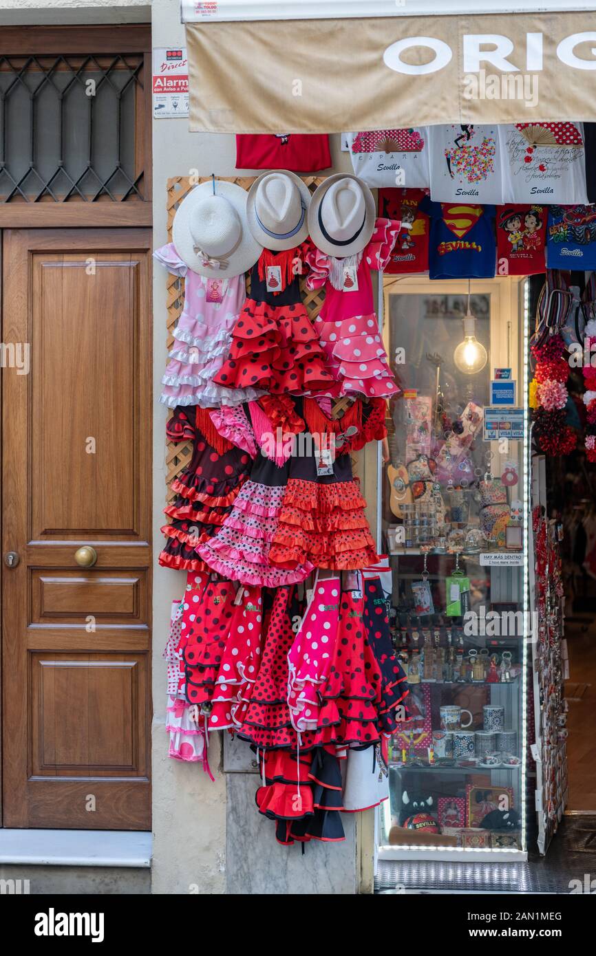 Sun hats and Flamenco dresses for sale at a tourist shop in Calle Hernando Colón, by Seville Cathedral Stock Photo