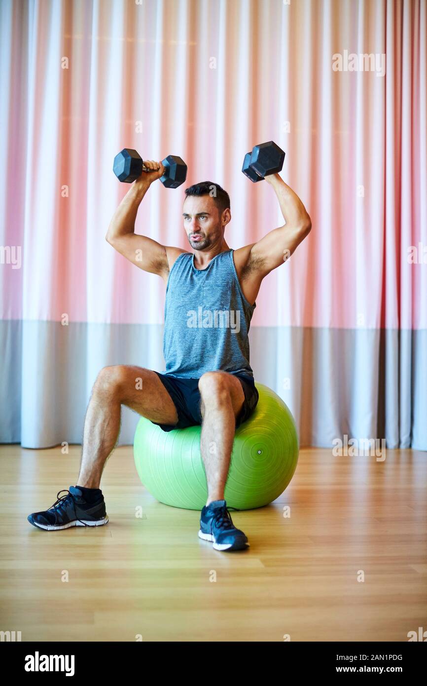 A man doing a shoulder press in the gym. Stock Photo
