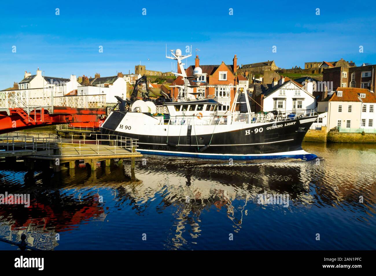 A fishing boat  H90 called 'Guiding Light' passing through the  Whitby Swing Bridge on its way into port Stock Photo