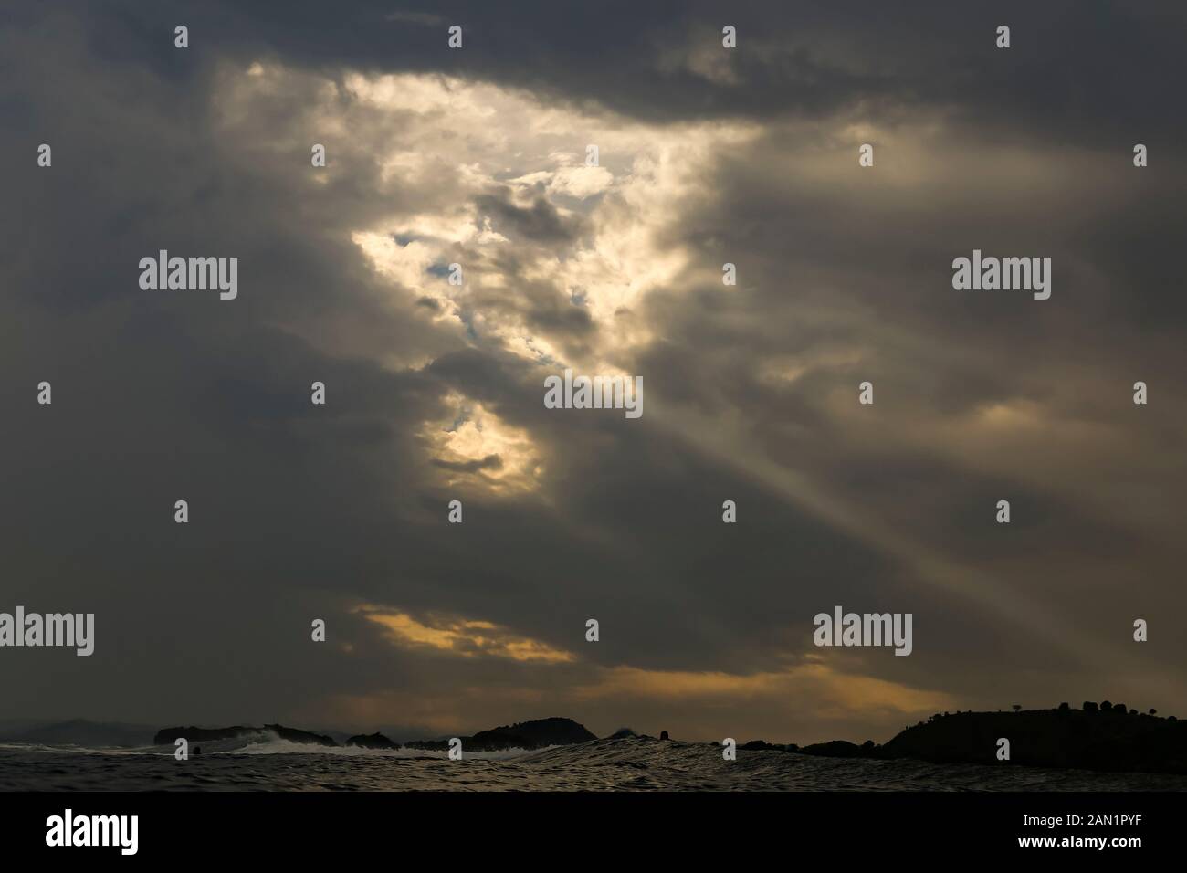 Sunlight shining through dark clouds Stock Photo