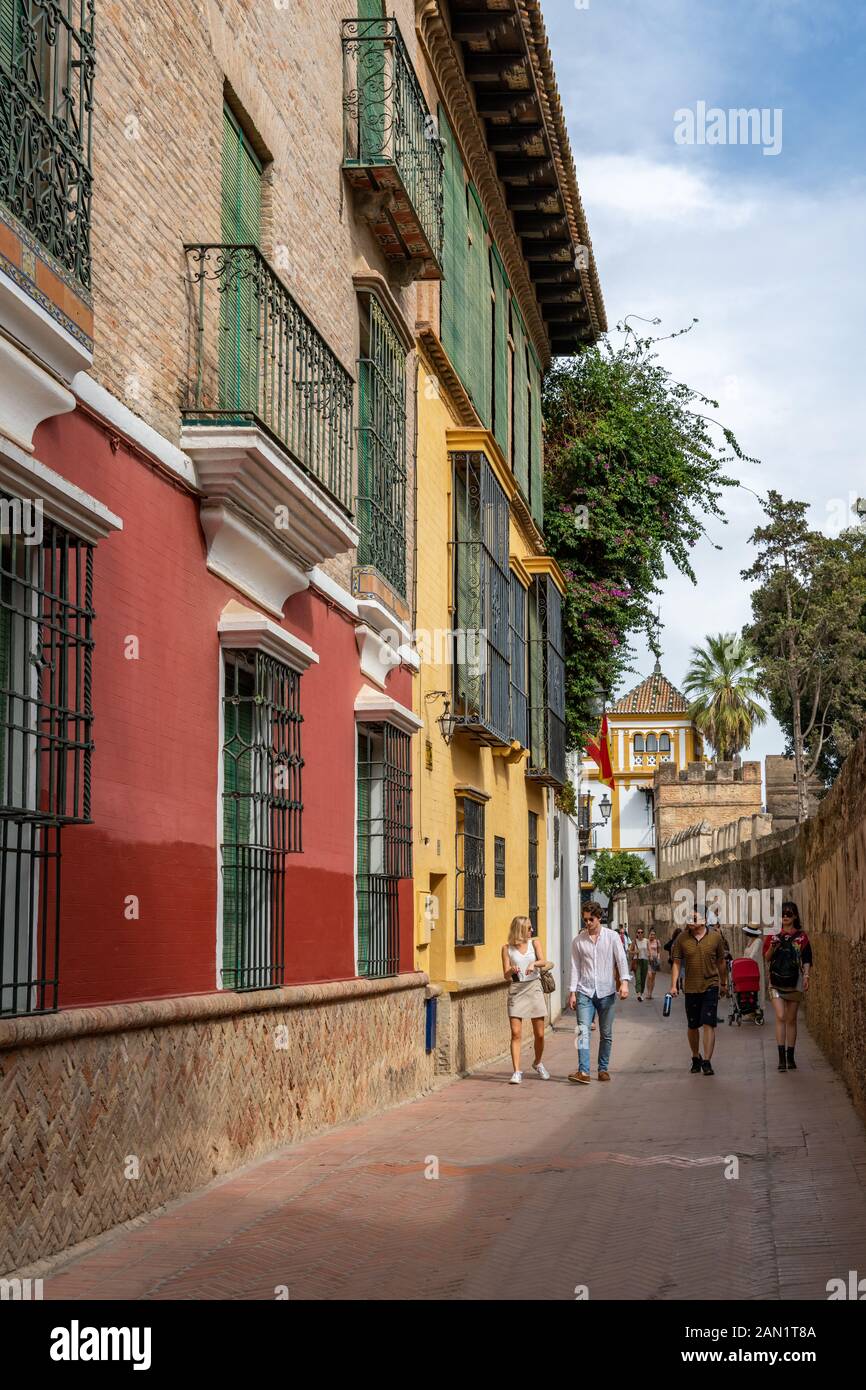 Colourful buildings line the narrow Callejon del Agua, which runs along the wall of the Real Alcázar. Stock Photo
