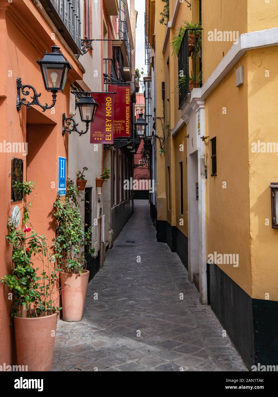 The narrow Calle Reinoso in Seville's old Jewish Quarter, a maze of narrow, streets, lanes and alleyways in the Barrio de Santa Cruz. Stock Photo