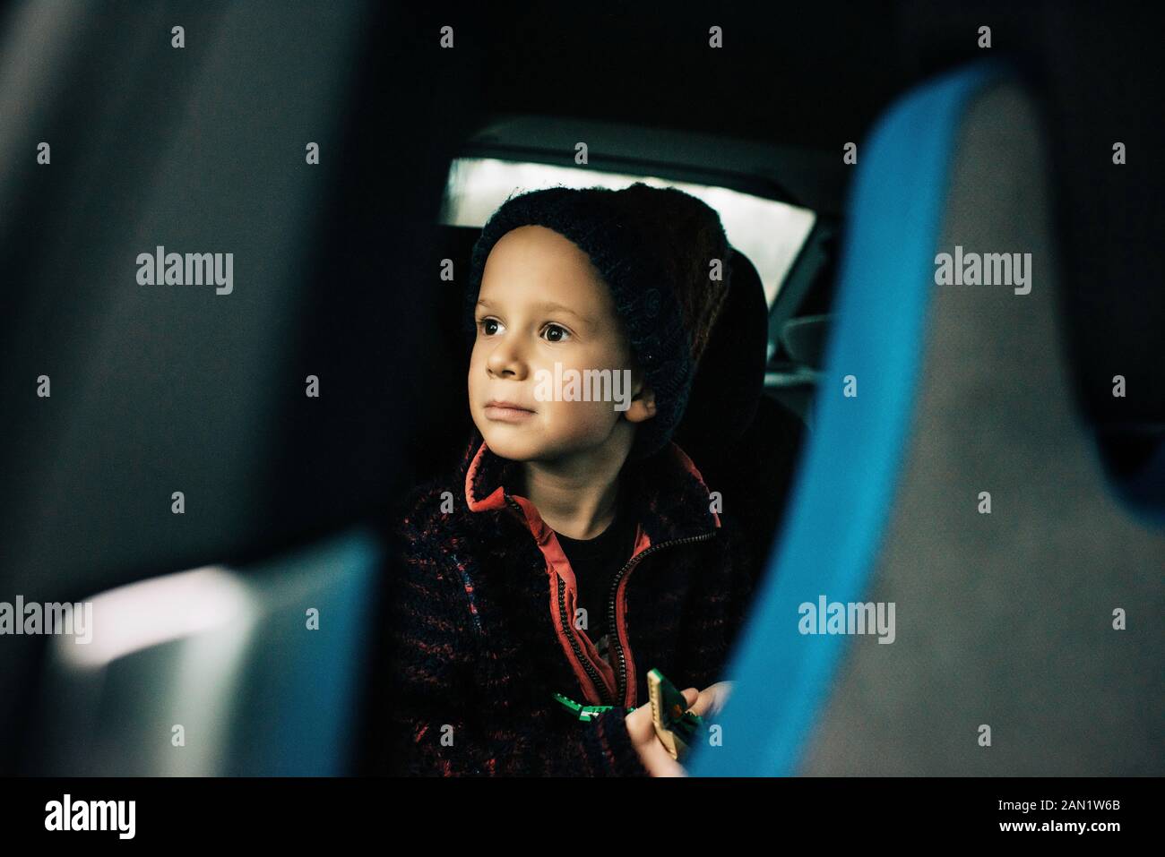 young boy sat in an electric car looking out the window Stock Photo