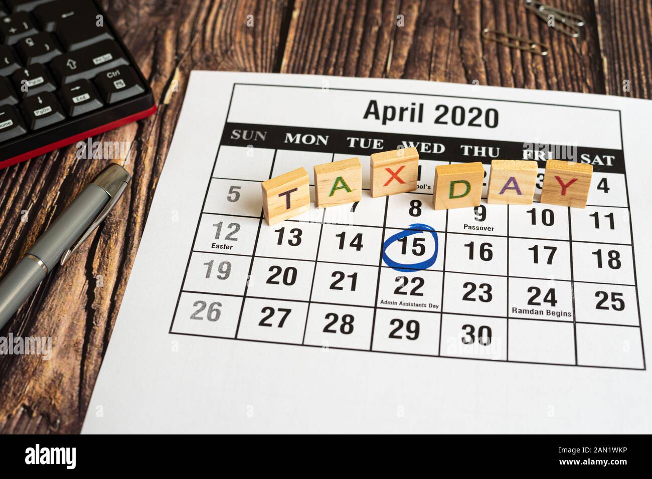 Tax day written with wooden letters to indicate the day of payment of taxes in america. Stock Photo