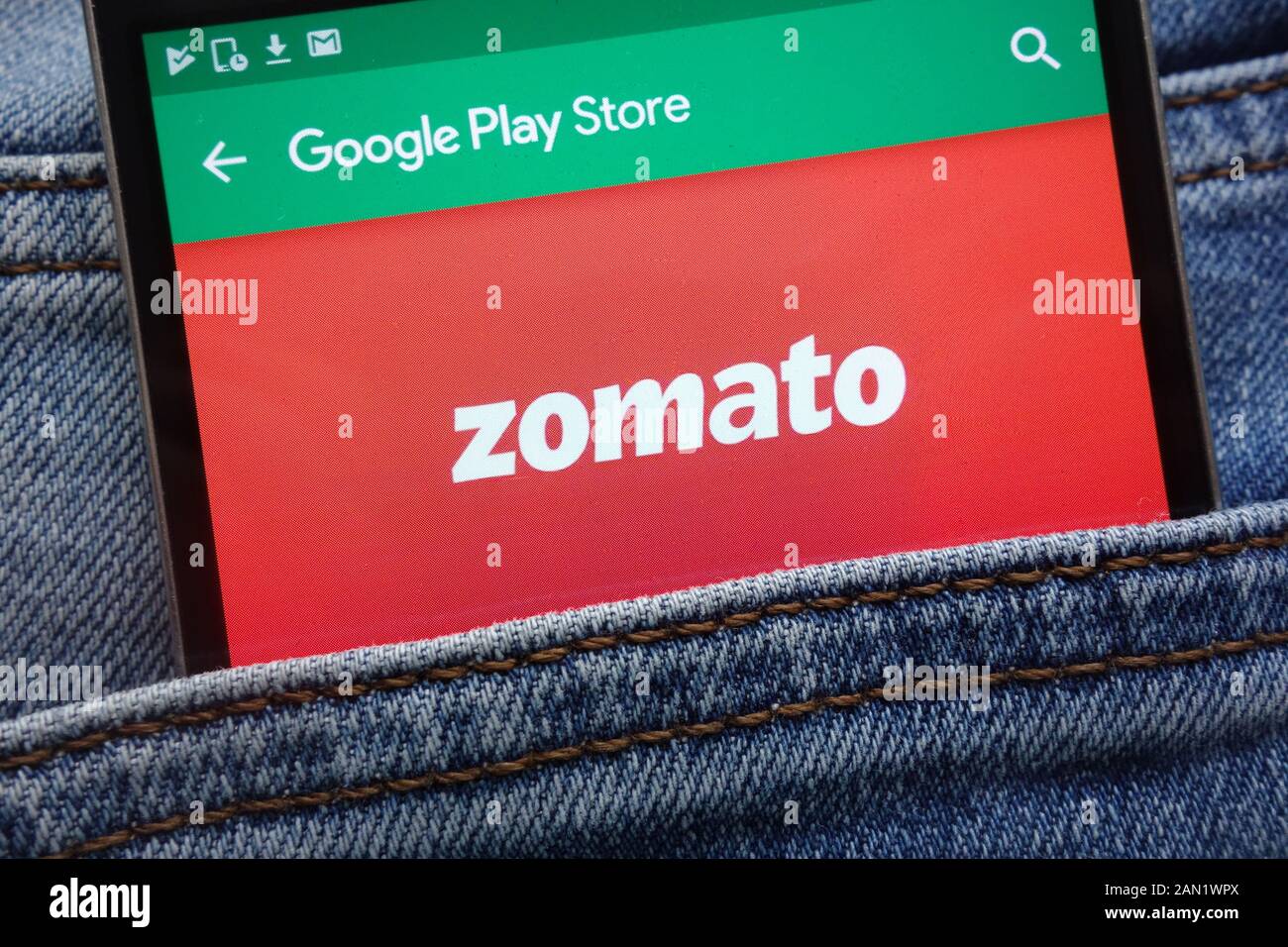 Zomato app on Google Play Store website displayed on smartphone hidden