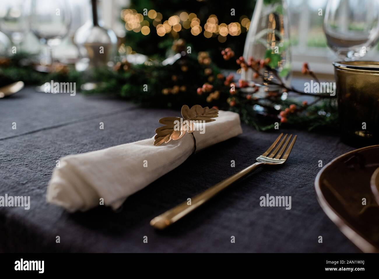 gold napkin holder on a decorated dinner table with candles Stock Photo