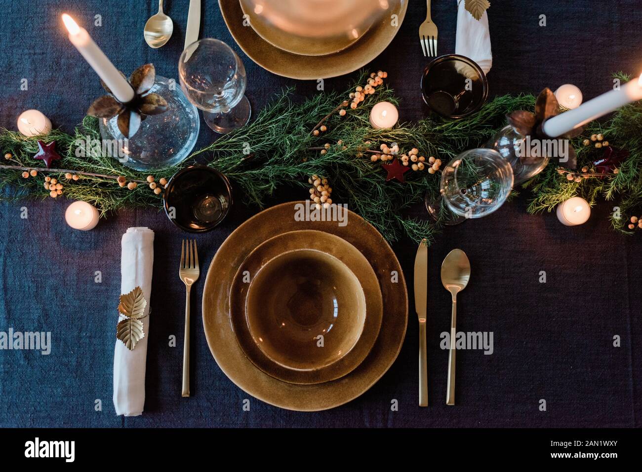 sky view of a modern dinner table setting with candles and greenery Stock Photo