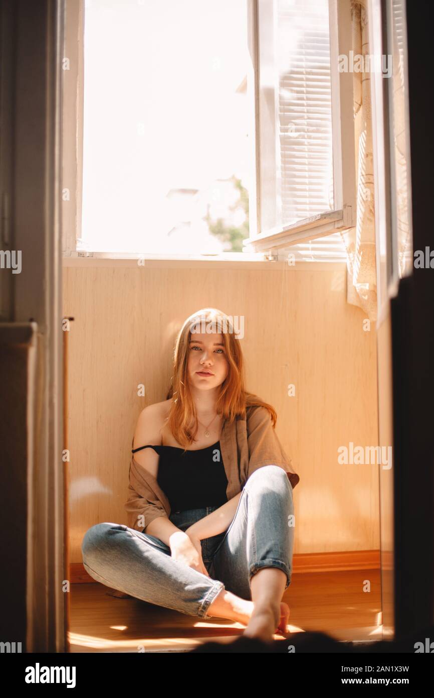 Cute teenage girl sitting on floor in balcony during summer Stock Photo ...