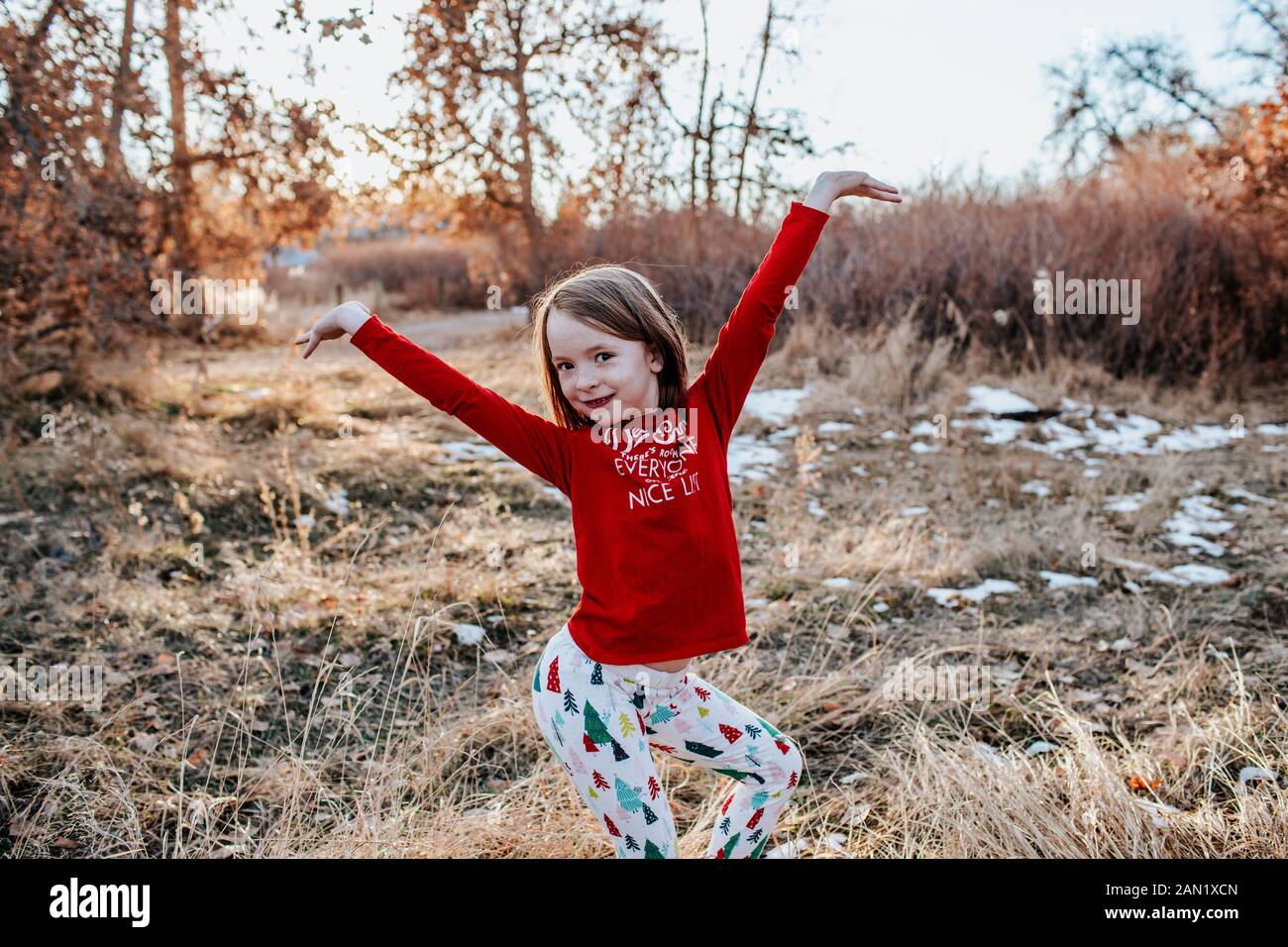 Young girl dancing in field in christmas leggings and shirt Stock Photo